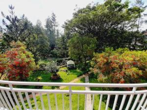 ein weißer Zaun mit Blick auf einen Garten mit Blumen in der Unterkunft Vila kota bunga in Cikundul