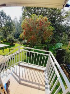 ein Balkon mit einem weißen Geländer und einem Baum in der Unterkunft Vila kota bunga in Cikundul