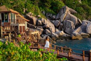 a woman standing on a bridge over a river at Dusit Buncha Koh Tao by Riya Group in Ko Tao