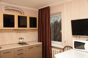 ドニプロにあるApartment na Kirova 94の大きな窓とテレビ付きのキッチンが備わります。
