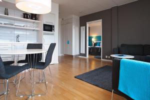 a kitchen and living room with a table and chairs at Sky Hotel Apartments Tornet in Linköping