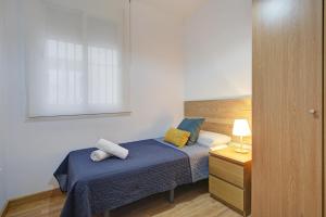 małą sypialnię z łóżkiem i szafką nocną w obiekcie Triana CACTUS w mieście Melilla