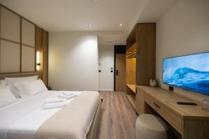 a hotel room with a bed and a flat screen tv at Beliz Boutique Hotel in Vlorë