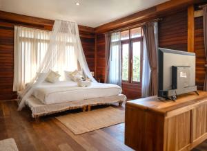 a bedroom with a bed and a tv in it at Dusit Buncha Koh Tao by Riya Group in Ko Tao