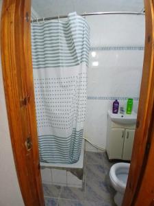 a bathroom with a shower curtain and a toilet at apartment for rent STD in Chişinău