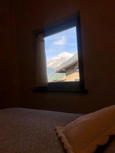 a bedroom window with a view of a mountain at TROIS COURONNES - GRANDE ROCHERE Appartamento di Charme a La Salle Valle d'Aosta in La Salle