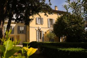 a large yellow house with windows and bushes at Villa Messori Spa in Castelvetro di Modena