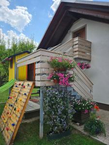a house with a ladder and flowers in front of it at Apartma Cifra Begunje in Begunje na Gorenjskem