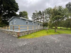 ケズウィックにあるSwallows Lodgeの木々のある石垣の上にある灰色の家