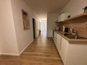 a kitchen with white cabinets and a wooden floor at 200qm - 9 rooms - Parkplatz - 3 Bäder - MalliBase Apartments in Garbsen +24 photos