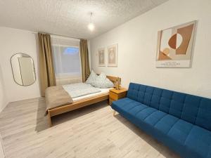 a room with a blue couch and a bed at 200qm - 9 rooms - Parkplatz - 3 Bäder - MalliBase Apartments in Garbsen