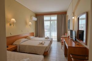 a hotel room with two beds and a television at Neda Hotel in Olympia