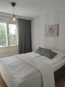 a bedroom with a large white bed with a window at Saunallinen tilava kaksio keskustan ja rautatieaseman tuntumassa in Hämeenlinna