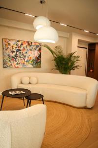 a living room with a white couch and a table at Penthouse Lebada Lake View in Pantelimon