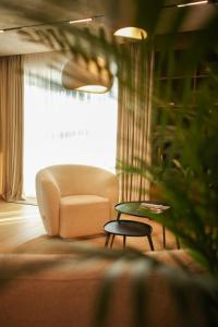 a living room with a couch and a chair and a table at Penthouse Lebada Lake View in Pantelimon