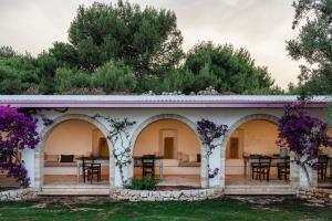 a house with purple flowers on the facade at Masseria Gorgognolo in Ostuni
