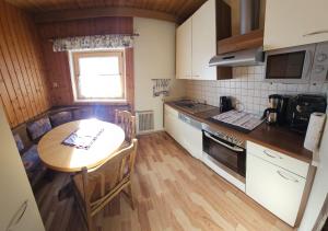 a small kitchen with a wooden table and a wooden floor at Leiterhütte in Patergassen