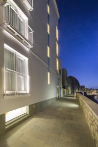 a building with windows and a sidewalk next to a building at Gaura Apartments in Trapani