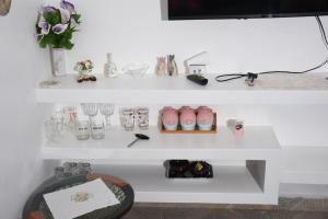 a white shelf with glasses and vases on it at 1, 2 & 3 bedroom serenity homes in Ongata Rongai 