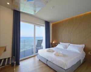 a bedroom with a large bed and a large window at Gaura Apartments in Trapani