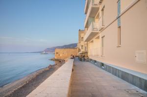 chodnik obok wody obok budynku w obiekcie Gaura Apartments w Trapani