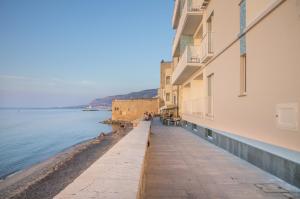 a sidewalk next to the water next to a building at Gaura Apartments in Trapani