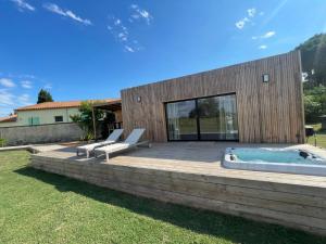 a backyard with a hot tub and a wooden deck at Lodge Sainte Sara in Aigues-Mortes