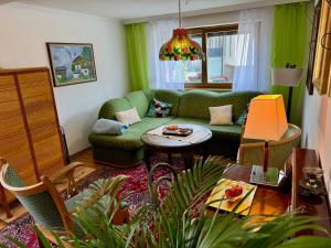 a living room with a green couch and a table at Blusnerhof in Virgen