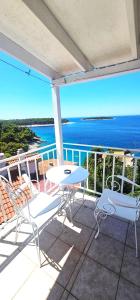 a balcony with a table and chairs and the ocean at Guest house Silvija - sea view in Primošten