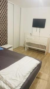 a bedroom with a bed and a flat screen tv at Arena La defense nanterre préfecture- Une chambre in Nanterre