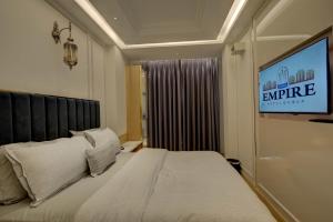 a hotel room with a bed and a tv at Empire Platinum Suites-Central Delhi in New Delhi