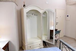a white cabinet in a room with a table at Casa Masaniello in Martina Franca