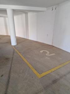 un parcheggio con una panchina bianca con il simbolo dei disabili di Corallo Bilocale Vista Collina a Nebida
