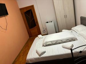 a bed with white sheets and pillows in a room at David și Daria in Vaslui +1 photo