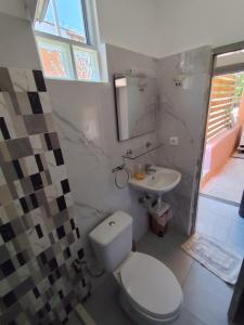a bathroom with a toilet and a sink at Garden Roses in Benitses