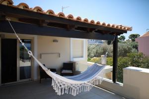 ラゴニッシにあるLuxury Villa with Pool in Athens Rivieraの家のバルコニーにハンモック