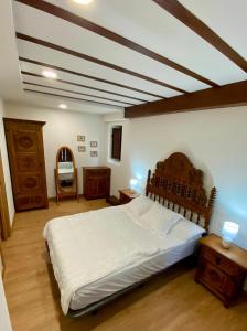 a bedroom with a large bed with a wooden headboard at Apartamento El rincón del Gato II in Santillana del Mar