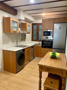 a kitchen with stainless steel appliances and a wooden table at Apartamento El rincón del Gato II in Santillana del Mar