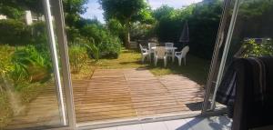 a view of a patio through a sliding glass door at Rêve de Bisca Appartement spacieux avec jardin privatif piscine et parking privés in Biscarrosse