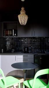 a kitchen with a table and chairs and a chandelier at Studio - Saint-Michel in Le Havre +9 photos