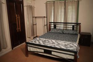 a bedroom with a bed and a cross on the window at Coffee Camp Home Stay with Tree house in Kattappana