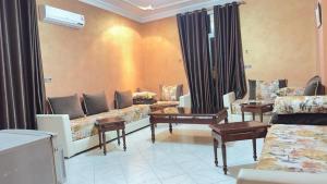a living room with couches and tables in a room at HOTEL FADOUA in Moulay Yacoub