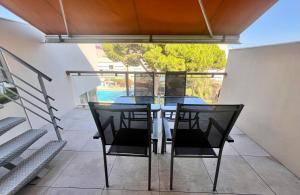 d'une table à manger et de chaises sur un balcon. dans l'établissement L'appart B42, à Gruissan
