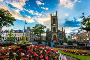 a clock tower in the middle of a city with flowers at The View from BIDE in Thurso +12 photos