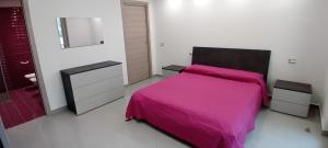 a bedroom with a pink bed and a mirror at B&B Carpe Diem Domus in Lacco Ameno