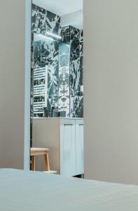 une cuisine avec des armoires blanches et un papier peint noir et blanc dans l'établissement Paillette, au Havre