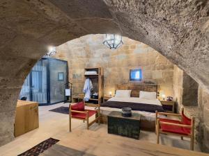 a bedroom with a bed in a stone wall at Obruk Kervansaray Museum Hotel in Obruk