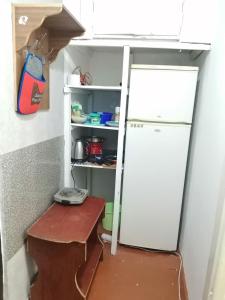 a refrigerator in a kitchen with a table and a shelf at Apartment for daily rent IND in Chişinău
