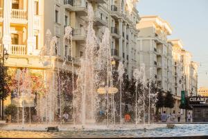 a fountain in the middle of a street with buildings at 5, 37, 65m2, Tashkent City Park, Boulevard in Tashkent