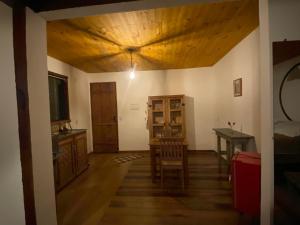 ラブラス・ノーヴァスにあるChalé da Mata Lavras Novasの木製の天井とテーブルのあるリビングルーム